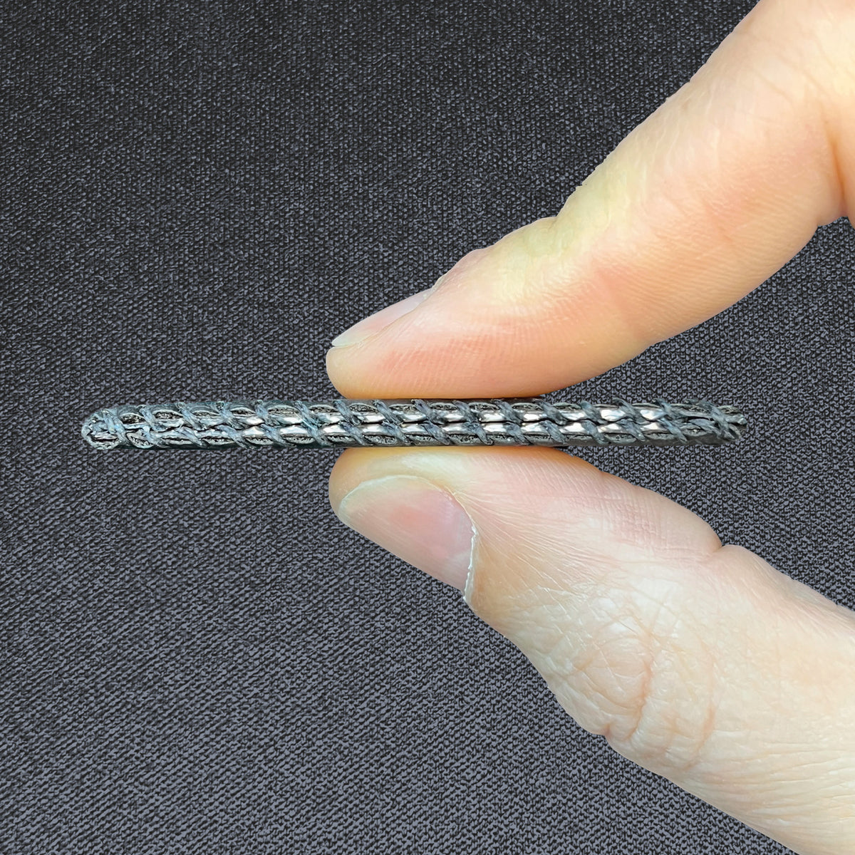 Black Wildcard, held between two fingers to show its slim profile