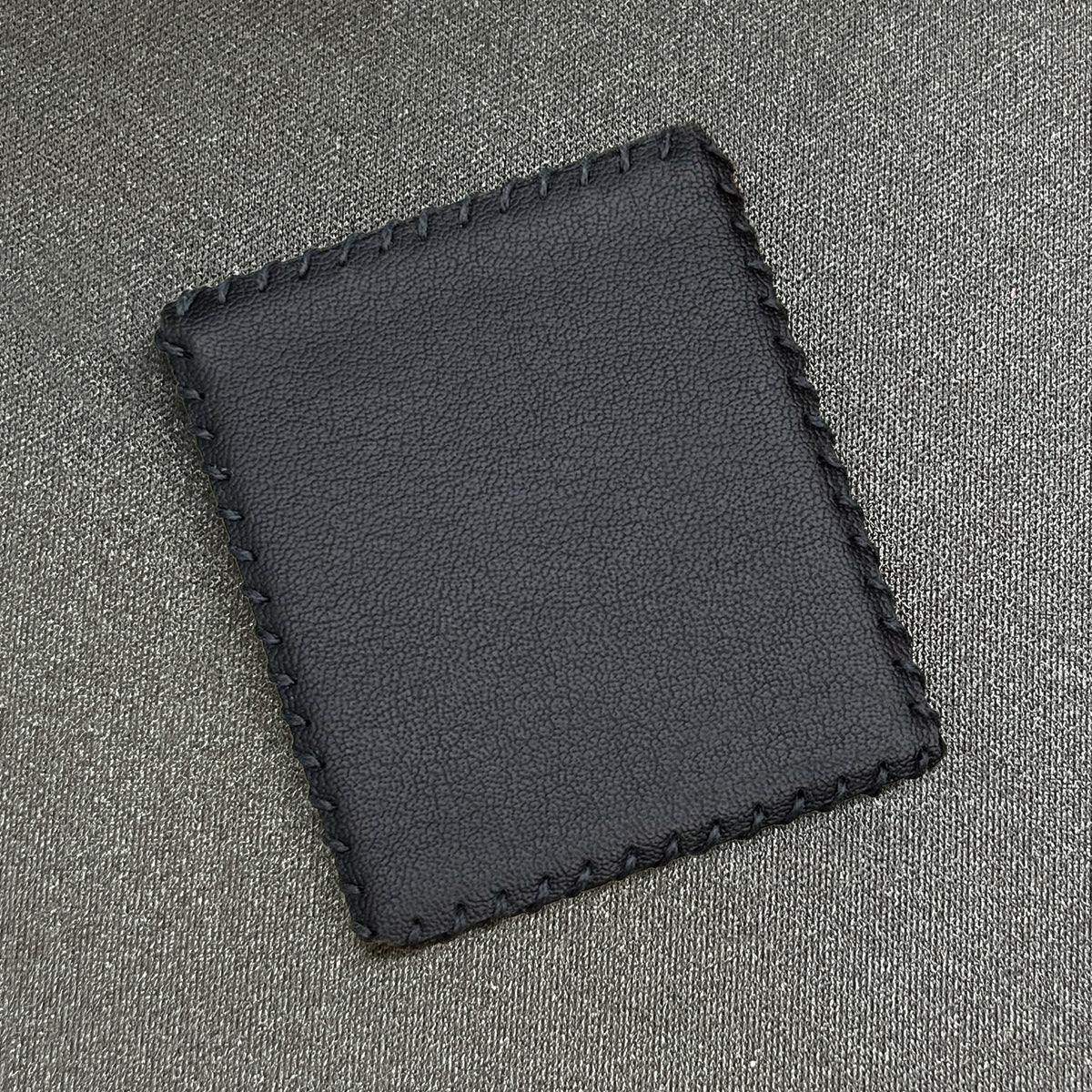 Black Wildcard, held between two fingers to show its slim profile